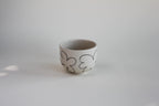 Ceramiczna czarka Oh z kamionki, kremowa z ręcznie rysowanym kwiatek w kolorze czarnym 