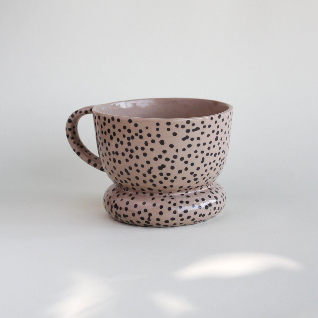Ceramiczny kubek OJ Kropki z kamionki z recyklingu, różowawy z czarnymi kropkami naniesionymi w masie, ręcznie robiony w pracowni Tokiart