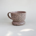 Ceramiczny kubek OJ Kropki z kamionki z recyklingu, różowawy z czarnymi kropkami naniesionymi w masie, ręcznie robiony w pracowni Tokiart