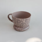 Ceramiczny kubek OJ Kropki, widok z przodu z widocznym wnętrzem, różowawa kamionka z czarnymi kropkami, ręcznie robiony Tokiart